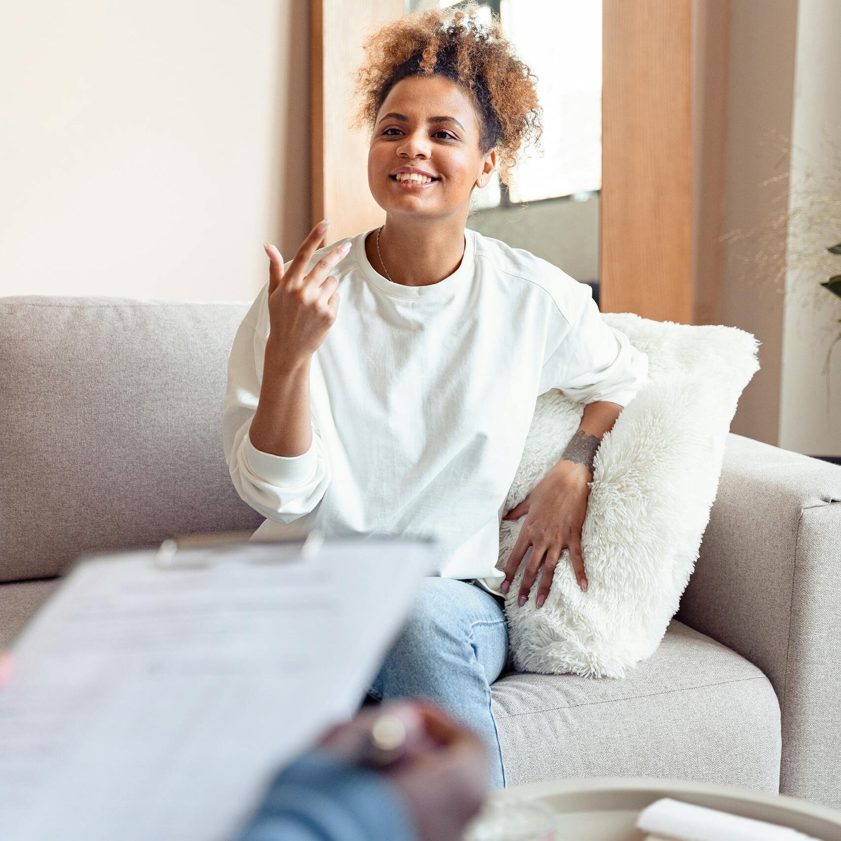 Smiling woman in a therapy session on a comfortable sofa.